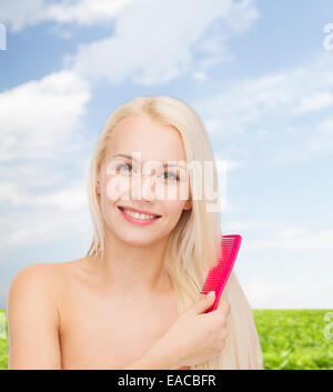 smiling woman with hair brush Stock Photo