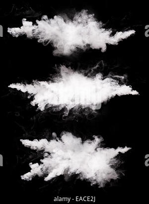 Freeze motions of white dust explosions isolated on black background Stock Photo