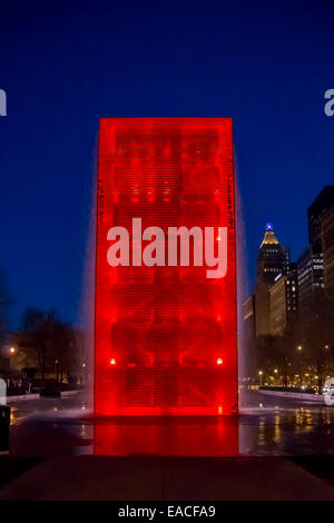 A fountain with a clear exterior changes color as LED bulbs inside glow different colors including the red shown here Stock Photo