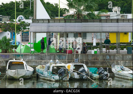 Mexican fishing boats tied up along the Campeche Melecon with fish market on sidewalk above the boats, Campeche, Mexico Stock Photo