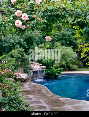 pool with waterfall and rose garden Stock Photo