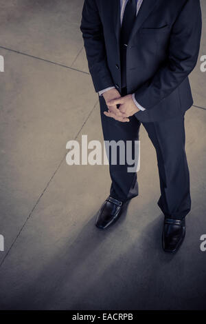 A business man in a suit stands waiting for someone. Stock Photo