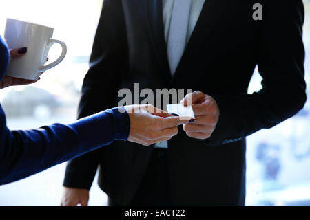 Concept shot of exchange business card between man and woman Stock Photo