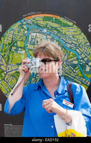 Tourist sightseeing – and taking a photograph – in and around Bath, Somerset UK.