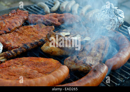 Barbecue meat, spare ribs and sausages on a grill, barbecue Stock Photo