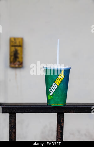 Subway drinks carton with drinking straw left abandoned on top of iron railing fence. Rhyl, Wales, Great Britain. Stock Photo