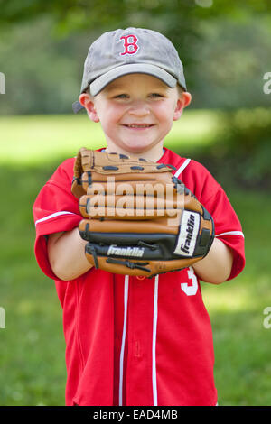 Little boy dressed ina baseball uniform with a baseball glove ready to play Stock Photo