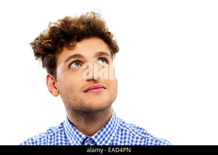 Pensive young man with curly hair looking up Stock Photo