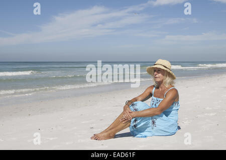 Mature woman sitting on Coquina Beach, Anna Maria Island, Florida Stock