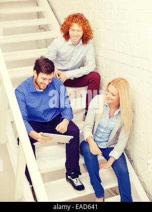 team with tablet pc computer sitting on staircase Stock Photo