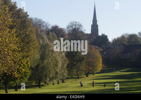 Wimbledon, London, UK. 12th November, 2014. Golfers practice on a golf ourse in the shadow of Wimbledon parish church on a sunny autumn day Credit:  amer ghazzal/Alamy Live News Stock Photo