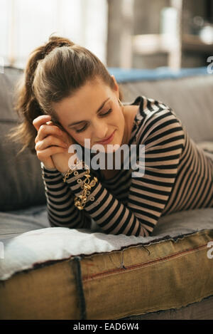 Relaxed young woman laying on divan in loft apartment Stock Photo