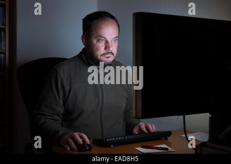 man sitting in front of computer at night Stock Photo
