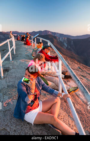 Tourists on the summit of Moro Rock a granite outcrop viewpoint in the Sequoia National Park, Yosemite, USA at sunset. Stock Photo