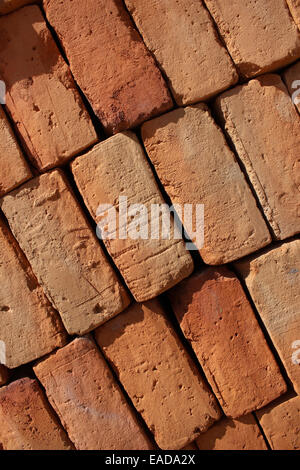 Brown handmade adobe bricks stacked for sale at an outdoor brickyard in Cotacachi, Ecuador Stock Photo