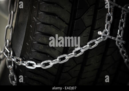 Horizontal detail shot of some new snow chains on a car's tire. Stock Photo