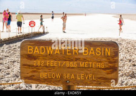 Tourists on salt pans Badwater in Death Valley which is the lowest, hottest, driest place in the USA, with an average annual rainfall of around 2 inches, some years it does not receive any rain at all. Stock Photo