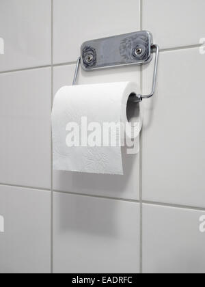 Toilet paper roll on metal holder Stock Photo