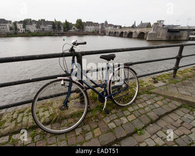 Bicycle chained to railings next to the river Maas in Maastricht, The Netherlands, Europe Stock Photo