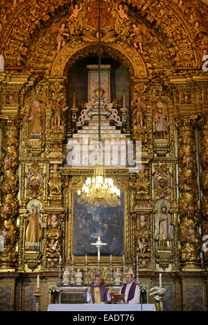 Priest celebrating catholic mass in front of the church altar Stock Photo