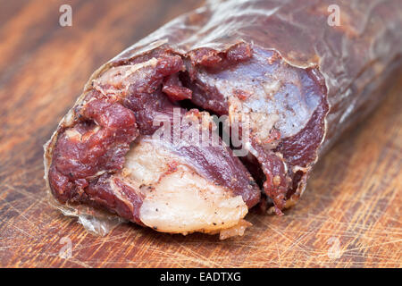 horse meat sausage kazy close up on chopping wood board Stock Photo