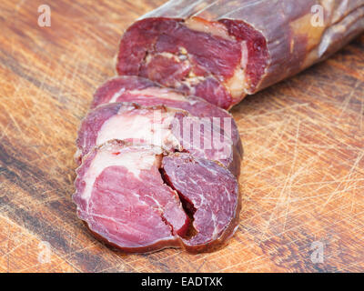sliced horse meat sausage kazy close up on cutting wooden board Stock Photo