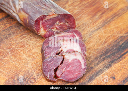 sliced horse meat sausage kazi close up on cutting wooden board Stock Photo