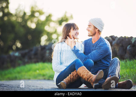 Happy Young Couple Having Fun Outdoors. Romantic Couple Kissing in Love on Country Road. Stock Photo