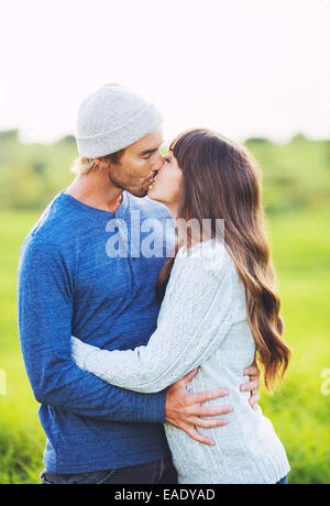 Happy Young Couple Having Fun Outdoors. Romantic Couple Kissing in Love. Stock Photo