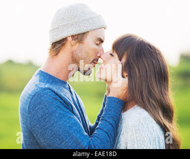 Happy Young Couple Having Fun Outdoors. Romantic Couple Kissing in Love on Country Road. Stock Photo