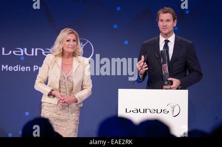 Berlin, Germany. 12th Nov, 2014. Former German national goalkeeper Jens Lehmann receives from the TV presenter Sabine Christiansen (L) the Laureus Media Award for his commitment at the 10th Laureus Media Award ceremony in Berlin, Germany, 12 November 2014. The Laureus Media Prize is attributed to people that have made an impact to the world of sport. Credit:  dpa picture alliance/Alamy Live News Stock Photo