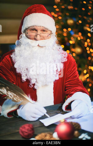 Portrait of happy Santa Claus answering Christmas letter Stock Photo