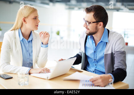 Two colleagues discussing ideas or project at meeting Stock Photo