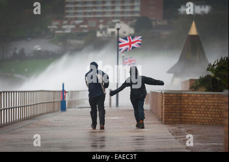 Walkers brave the elements as stormy weather batters the coast in Teignmouth, Devon, UK. Stock Photo