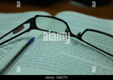 Reading glasses on an open book Stock Photo