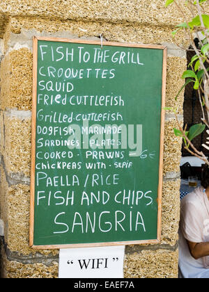 Tapas blackboard menu in a stone wall. Stock Photo