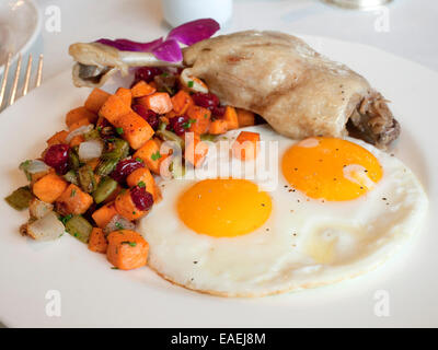 Sunny side up egg breakfast with duck confit, carrots, celery and cranberries. Stock Photo