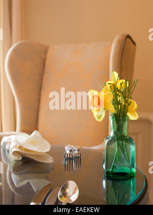 flower bouquet daffodils vase table setting flatware dining room spring yellow meal napkin chair Stock Photo