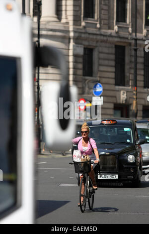 A female cyclist indicating a right turn in London traffic Stock Photo