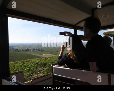 Le Train Des Grands Vignobles at St Emilion, Bordeaux, France.  Visitors taking photographs from the train. Stock Photo