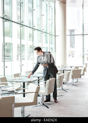 waiter setting table in upscale restaurant Stock Photo
