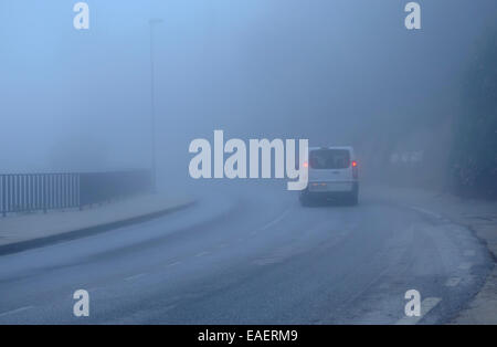 Car van driving in fog. foggy road, rear lights on red,  misty mountain road. Spain. Stock Photo