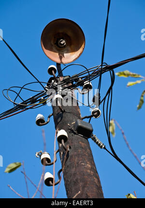 wooden telegraph pole with old street lamp closeup on blue sky background Stock Photo