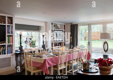 Christmas lunch laid on farmhouse table with gingham tablecloth and antique dining chairs Stock Photo