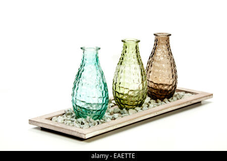 three decorative glass vases on stand with pebbles Stock Photo