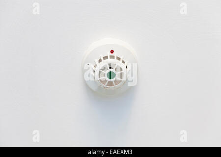 Ceiling mounted white smoke detector as part of a fire alarm system in the UK Stock Photo