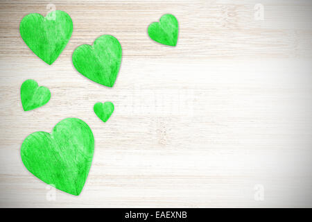 Wooden green hearts on white timbered background. Stock Photo