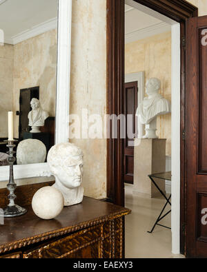 View through open doorway to large plaster bust on plinth Stock Photo