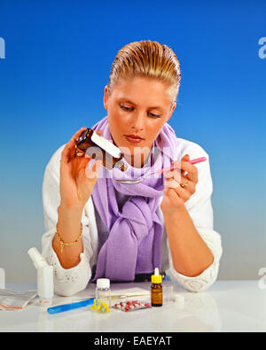 Blond woman taking medicine for cold Stock Photo