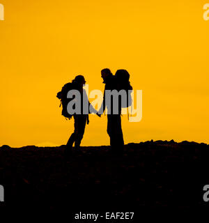 Silhouette of Backpacking Couplle having a special moment at sunset,USA Stock Photo